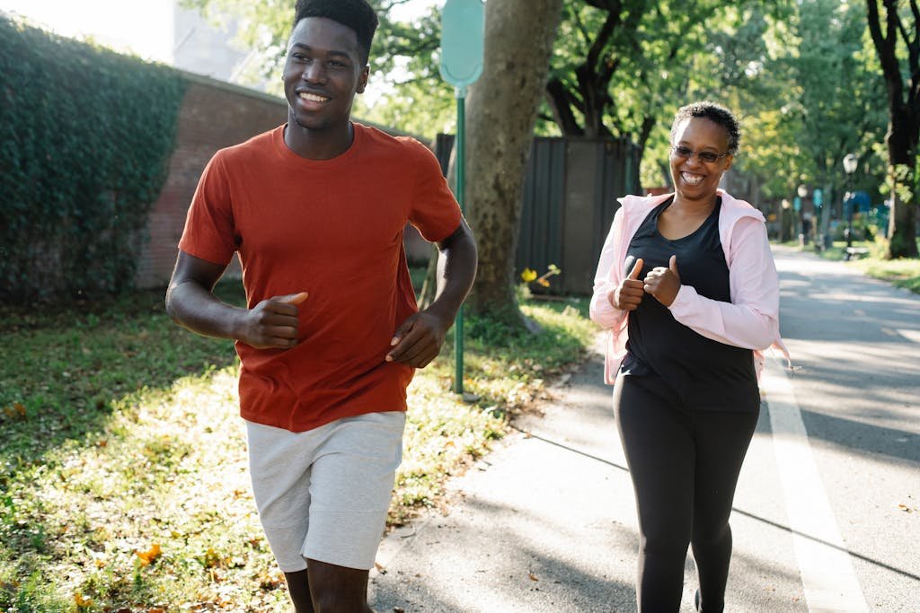 Happy couple enjoys running a sunny park, embracing a healthy lifestyle.
